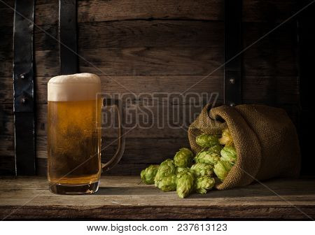 Oktoberfest Beer Barrel And Beer Glasses With Wheat And Hops On Wooden Table.