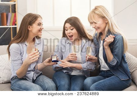 Young Happy Girl Showing Her Proposal Ring To Surprised Girlfriends. Best Friends Celebrate One Of T