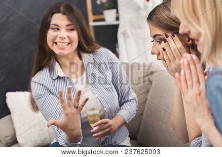 Young Happy Girl Showing Her Proposal Ring To Surprised Girlfriends. Best Friends Celebrate One Of T