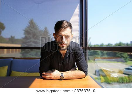 Caucasian Businessman Sitting At Office On Sofa And Wearing Black Shirt. Concept Of Responsibility A