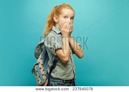 Portrait Of Emotional Girl In Uniform And Backpack On Shoulders, Covered Her Mouth With Hands, Expre