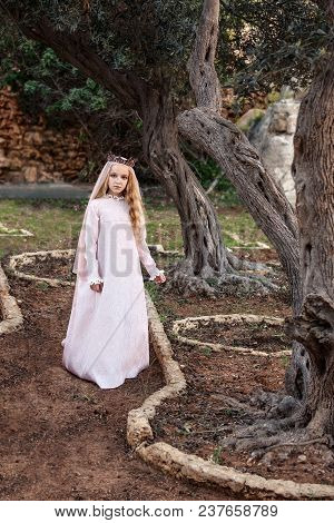 A Little Princess Of Spirits And Fairies Stands In The Enchanted Mysterious Magic Forest In A Weddin