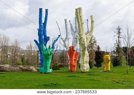 Vila Nova de Famalicao, Portugal - March 31, 2018: Urban art made of colorful painted dead trees in Parque da Devesa Urban Park.
