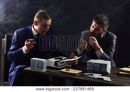 Men Sitting At Table With Piles Of Money And Typewriter. Company Engaged In Illegal Business. Illega