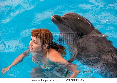 Young Happy Girl Hugs With Dolphin