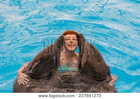 Young Happy Girl Hugs With Dolphin