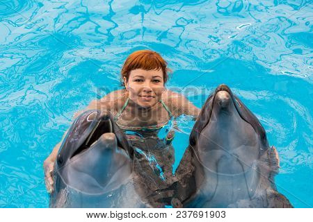 Young Happy Girl Hugs With Dolphin
