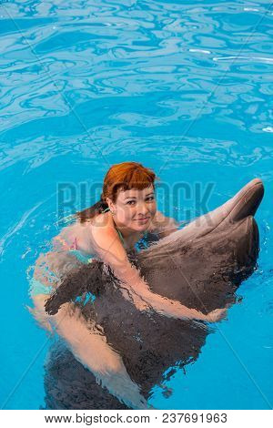 Young Happy Girl Hugs With Dolphin