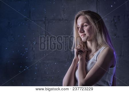 Portrain Of The Girl In The White Shirt With Water Drop In A Dark Room Illuminated By Light During A