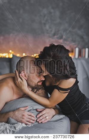 Girl Gently Hugs The Neck, A Bald Beefy Man.