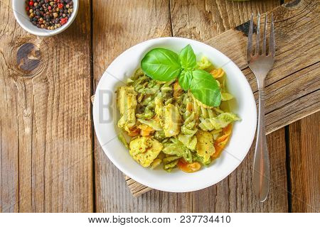 Pasta With Chicken Pieces And Pesto Sauce On An Old Wooden Table