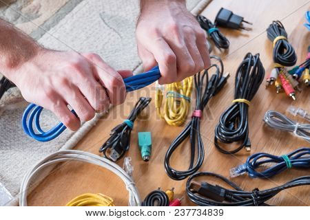Male Hands Hold The Blue Cable, Brings Order