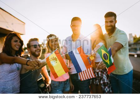 Group Of People Holding National Flags And Having Fun On Rooftop