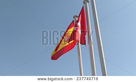 Flags Of Spain And The Community Of Madrid Waving. Mast Seen From Below