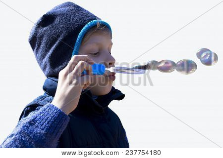 The Boy Blows Bubbles. With A Slight Breeze Of Air They Fly Away. Isoleted Photo.