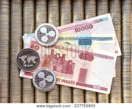 Silver Crypto Coins Ripple Xrp, Paper Denominations Belarusian Ruble. Metal Coins Are Laid Out In A 