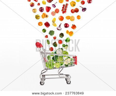 Grocery Cart With Vegetables And Fruits Falling In It Isolated On White. Healthy Meals Shopping, Cor
