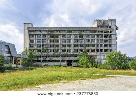 Sebes, Romania - September 01, 2017: Daylight View To Old Abandoned Building In Mountains. Green Tre