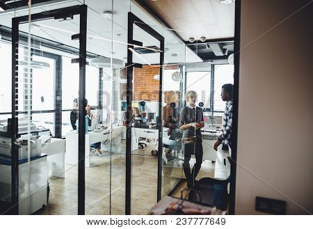 Industrious Young People Who Work In The Modern Office With Glass Walls