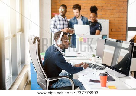 Startup Business Worker Is Typing Important Document With Wearing Headphones Because Of The Noisy Ro