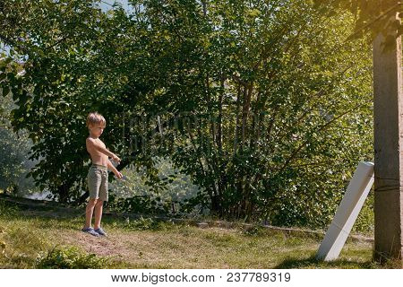 Portrait Of Little Blond Boy Throwing Kunai At The Target