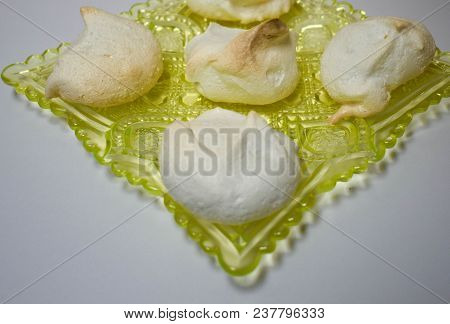 Meringues On A Yellow Vaseline Glass Plate.