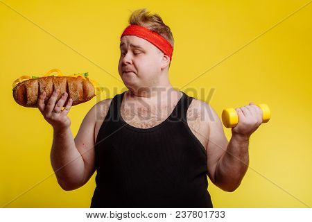 Fat Sportsman Has Ruined The Diet With Yummy Humburger. Gluttony.