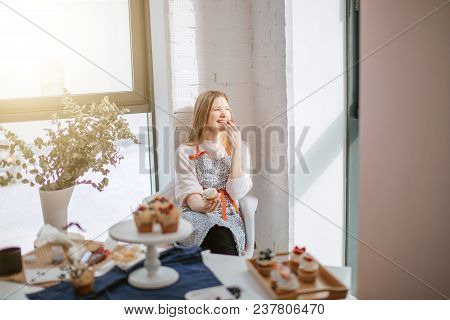 Morning Of Beautiful Young Woman Having Capcake And Smiling, Looking At Window