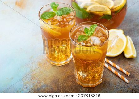 Traditional Iced Tea With Lemon, Mint And Ice In Tall Glasses. Two Glasses With Cool Summer Drink On