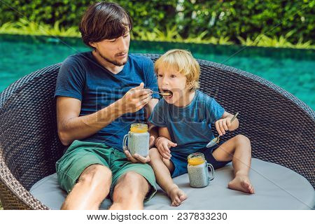 Father And Son Eat Dessert With Chia Seeds And Mangoes By The Pool In The Morning. Healthy Eating, V