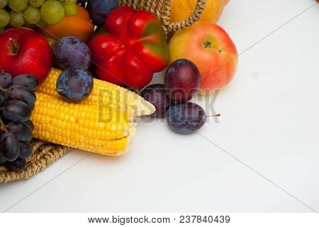 Vegetables And Fruits In Rustic Basket Isolated On White. Healthy Food.
