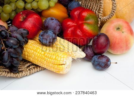 Vegetables And Fruits In Rustic Basket Isolated On White. Healthy Food.