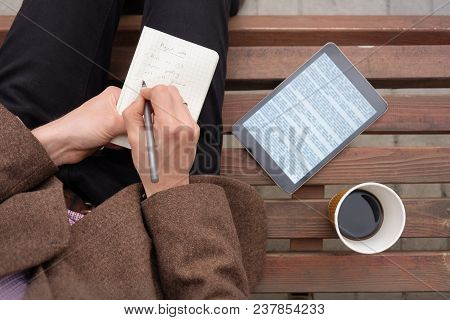 Working With Text Outside In Town With Note Pad And Tablet Computer, Top View. Shot From Above Of St