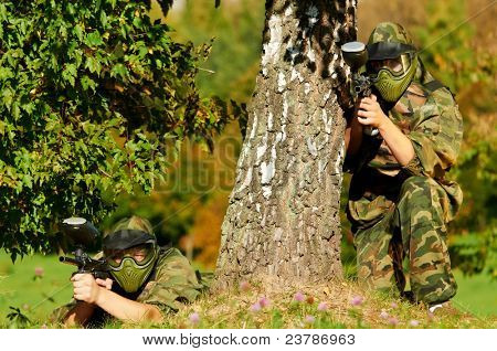 Prootective iki paintball spor oyuncu koyar ve hedefleyen ve shoting dışarıda silahla maske