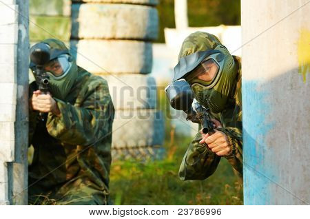 Prootective iki paintball spor oyuncu koyar ve hedefleyen ve shoting dışarıda silahla maske