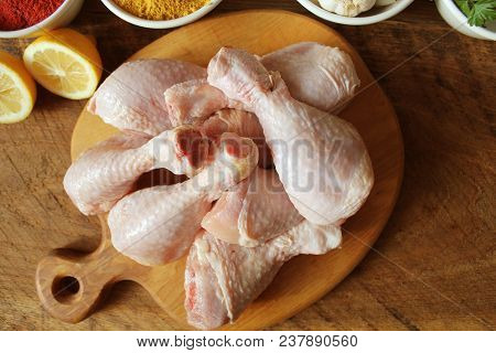Raw Uncooked Chicken Legs, Drumsticks On Cuttingn Board, Meat With Ingredients For Cooking