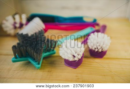 Cleaning House Or Office Concept. A Set Of Colorful Plastick Brushes On A Light Wooden Background, C