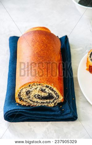 Traditional Polish Festive Pastry - Makowiec- Poppy Seed Roll On A  White Stone Background.
