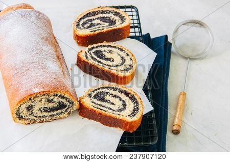 Traditional Polish Festive Pastry - Makowiec- Poppy Seed Roll Covered With Powdered Sugar On A  Whit