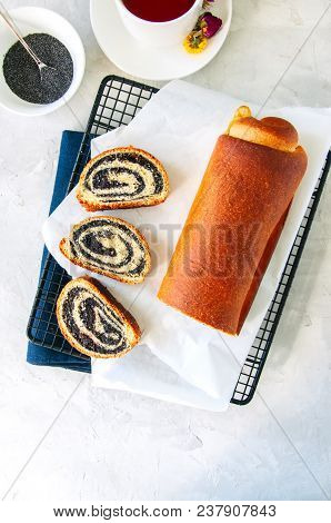 Traditional Polish Festive Pastry - Makowiec- Poppy Seed Roll On A Wire Rack On A White Stone Backgr