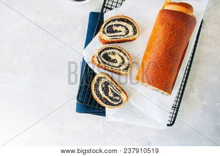 Traditional Polish Festive Pastry - Makowiec- Poppy Seed Roll On A Wire Rack On A White Stone Backgr
