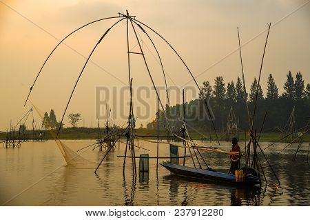 Udonthani, Thailand - Decmber 9, 2011: Fisherman On Boat Fishing By Using Traditional Net Fishing To