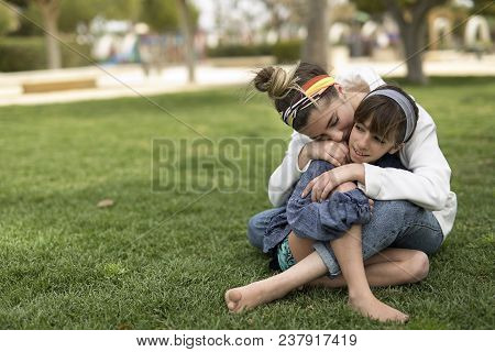 Two Sisters Who Sitting Loving Each Other.