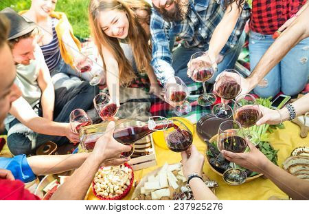 Side View Of Friends Serving And Toasting Red Wine Glasses - Millennials Having Fun Cheering At Picn
