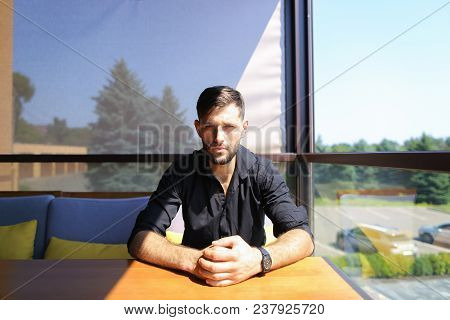 American Businessman Sitting At Office On Sofa And Wearing Black Shirt. Concept Of Flora Background 