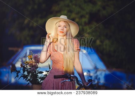 Beautiful Girl Wearing A Nice Dress Having Fun In A Country House With A Bicycle, Holding A Beautifu