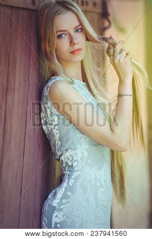 Attractive Modest Young Blond Woman Playing With Hair On Red Wooden Background Her Hair Painted In P