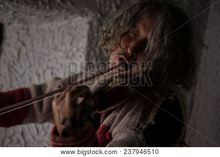 Old Man With Tousled Long Hair Singing As He Plays A Violin Totally Immersed In The Music With His E