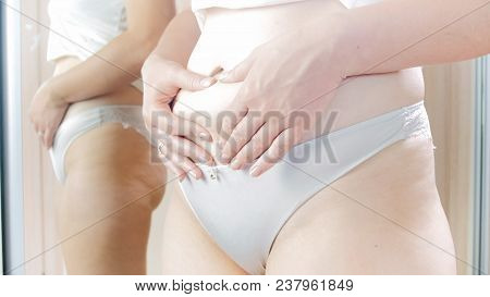 Young Woman In Panties With Big Belly Standing At Mirror