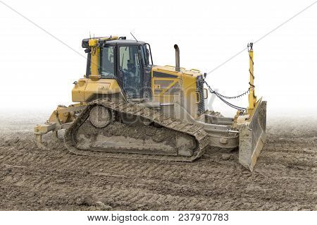 Yellow Bulldozer At A Loamy Construction Site, Partly Isolated In White Back